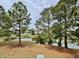 View of a backyard pond with trees, grassy areas and residential buildings at 3979 Forsythia Ct. # 203, Myrtle Beach, SC 29588