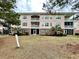Multi-story condo building with balconies and a grassy common area in front at 3979 Forsythia Ct. # 203, Myrtle Beach, SC 29588