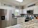 Well-lit kitchen with white cabinets, stainless appliances, and granite counters at 3979 Forsythia Ct. # 203, Myrtle Beach, SC 29588