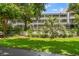 Multi-story building with screened balconies, manicured lawn, and lush landscaping at 415 Ocean Creek Dr. # 2216, Myrtle Beach, SC 29572