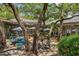 Charming outdoor patio with tables, chairs, and shade umbrellas surrounded by lush trees at 415 Ocean Creek Dr. # 2216, Myrtle Beach, SC 29572