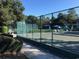 Well-maintained tennis courts surrounded by tall fences, trees, and manicured bushes at 415 Ocean Creek Dr. # 2216, Myrtle Beach, SC 29572