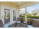 Inviting screened porch with cozy seating and serene views of the surrounding green landscape at 432 Warrington Way # 432, Murrells Inlet, SC 29576