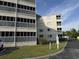 View of condo building exterior with screened balconies, green grass, and blue sky at 4350 Intercoastal Dr. # 2302, Little River, SC 29566