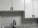 Close up of a modern kitchen featuring granite counters, gray backsplash, and white cabinets at 4350 Intercoastal Dr. # 2302, Little River, SC 29566