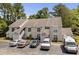 Two-story condo building with multiple parking spaces in front and lush trees surrounding the property at 4470 Little River Inn Ln. # 1005, Little River, SC 29566