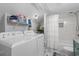 Well lit laundry area includes washer, dryer, storage shelves, and tiled shower/tub combo at 4470 Little River Inn Ln. # 1005, Little River, SC 29566