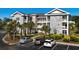 Well-maintained condo building featuring stone facade, balconies, and convenient parking at 4749 Wild Iris Dr. # 205, Myrtle Beach, SC 29577