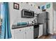Galley kitchen featuring white cabinets, stainless steel appliances, and black countertops at 4749 Wild Iris Dr. # 205, Myrtle Beach, SC 29577