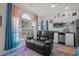 Living room with a black leather loveseat, hardwood floors, and modern kitchen appliances at 4749 Wild Iris Dr. # 205, Myrtle Beach, SC 29577