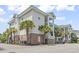 Exterior view of the condo featuring palm trees and manicured landscaping at 4803 Bovardia Pl. # 104, Myrtle Beach, SC 29577