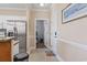 Hallway view of the interior featuring neutral walls, modern appliances, and doorway leading to the bedroom at 4803 Bovardia Pl. # 104, Myrtle Beach, SC 29577