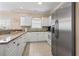 Bright kitchen with granite countertops, white cabinets, and modern stainless steel refrigerator at 4803 Bovardia Pl. # 104, Myrtle Beach, SC 29577