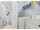 Functional laundry room features modern appliances and storage, adjacent to a well-appointed bathroom at 4803 Bovardia Pl. # 104, Myrtle Beach, SC 29577