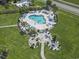 Aerial view of a community pool surrounded by lush landscaping, lounge chairs, and well-maintained green spaces at 4803 Bovardia Pl. # 104, Myrtle Beach, SC 29577