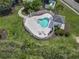 Aerial view of a heart-shaped pool with lounge chairs, landscaped surroundings, and white picket fence at 4803 Bovardia Pl. # 104, Myrtle Beach, SC 29577