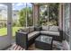 Enclosed sun room featuring comfortable outdoor seating, brick accents, and a colorful rug for a cozy atmosphere at 4803 Bovardia Pl. # 104, Myrtle Beach, SC 29577