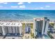 Aerial view of the condos and hotel with a beautiful beach, blue ocean, and blue skies at 4814 Greenhaven Dr., North Myrtle Beach, SC 29582