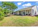 View of a large green backyard featuring a covered screened porch with outdoor seating at 4814 Greenhaven Dr., North Myrtle Beach, SC 29582