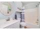Clean bathroom with a white vanity, mosaic mirror, and tub with striped curtain at 4847 Carnation Circle # 201, Myrtle Beach, SC 29577