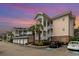 Beautiful condo complex featuring garages, stairs to unit entrances, palm trees, and accessible parking at 4847 Carnation Circle # 201, Myrtle Beach, SC 29577