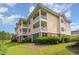 Multi-story condo with balconies overlooking lush landscaping and manicured lawns at 4847 Carnation Circle # 201, Myrtle Beach, SC 29577