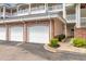 Close-up view of the garages with brick accents, landscaping, and walkway to the condo unit at 4847 Carnation Circle # 201, Myrtle Beach, SC 29577