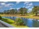 Tranquil pond and golf course view from a patio, showcasing a beautiful landscape at 4847 Carnation Circle # 201, Myrtle Beach, SC 29577