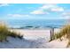 Beautiful beach with sand dunes and clear blue water under a partly cloudy sky at 503 20Th Ave. N # 15-A, North Myrtle Beach, SC 29582