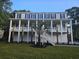 Stunning two-story home with a spacious porch, palm trees, and a well-maintained lawn at 507 Hillside Dr. N, North Myrtle Beach, SC 29582