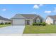 Charming single-story home featuring a well-manicured lawn and a two-car garage at 5107 Capulet Circle, Myrtle Beach, SC 29588