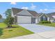 Traditional home exterior featuring a two-car garage and meticulously maintained landscaping at 5107 Capulet Circle, Myrtle Beach, SC 29588