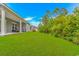 Lush green backyard featuring a covered patio, extending into a tree-lined property at 5309 Abbey Park Loop, Myrtle Beach, SC 29579