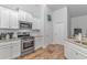 Modern kitchen featuring stainless steel appliances, white cabinetry, and wood-look flooring at 5309 Abbey Park Loop, Myrtle Beach, SC 29579