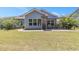 Lush backyard featuring a covered patio, grill, and manicured lawn at 5581 Plantersville Pl., Myrtle Beach, SC 29579