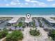 Aerial view of condos with a pool, palm trees, parking, and beautiful beach access and ocean views at 5601 N Ocean Blvd. # C-106, Myrtle Beach, SC 29577