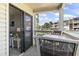 Balcony with outdoor furniture offers serene views of palm trees, pool, and lush landscape at 5601 N Ocean Blvd. # C-106, Myrtle Beach, SC 29577