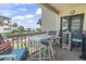 Inviting balcony with seating overlooking the ocean, beach, and surrounding palm trees at 5601 N Ocean Blvd. # C-106, Myrtle Beach, SC 29577