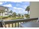 Balcony view overlooking lush landscaping, mature palm trees and the ocean in the distance at 5601 N Ocean Blvd. # C-106, Myrtle Beach, SC 29577