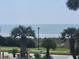 Scenic ocean view framed by lush palm trees, offering a glimpse of sandy shores at 5601 N Ocean Blvd. # C-106, Myrtle Beach, SC 29577