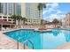Resort-style pool area surrounded by lounge chairs, palm trees, and a high-rise building at 609 Hillside Dr. S # C-10, North Myrtle Beach, SC 29582