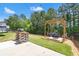 Inviting backyard featuring a charming pergola swing and barbecue area, ideal for outdoor entertaining at 6485 Royal Pine Dr., Myrtle Beach, SC 29588