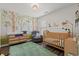Charming Bedroom featuring playful wall murals, a cozy chair, and a wooden crib at 6485 Royal Pine Dr., Myrtle Beach, SC 29588