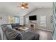 Bright and airy living room with a comfy sectional sofa, entertainment center, and a decorative ceiling fan at 6485 Royal Pine Dr., Myrtle Beach, SC 29588