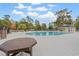 Resort-style pool and wooden picnic table surrounded by lush greenery and ample space for relaxation at 6485 Royal Pine Dr., Myrtle Beach, SC 29588
