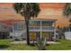 Coastal home featuring dual balconies, palm trees, and lush lawn at 668 S Waccamaw Dr., Murrells Inlet, SC 29576