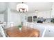 Cozy kitchen and dining area with white cabinetry, stainless steel appliances, and vintage chandelier at 668 S Waccamaw Dr., Murrells Inlet, SC 29576