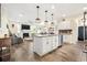 Open-concept kitchen showcasing a center island with pendant lights and stainless steel appliances that flows into the living room at 700 Lorenzo Dr., North Myrtle Beach, SC 29582