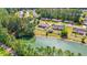 An aerial view showcasing a lakeside home with a fenced backyard, nestled in a serene, wooded community at 7012 Walden Ct., Myrtle Beach, SC 29588
