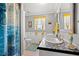Neutral bath with dual sinks, vanity, window, tile floor and coastal-themed decor at 7012 Walden Ct., Myrtle Beach, SC 29588